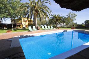 una gran piscina con palmeras y una casa en Catalunya Casas Incredible secluded villa, just 11km from Beach!, en La Selva del Camp