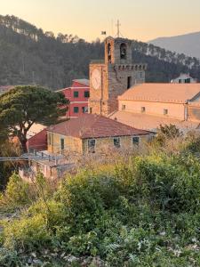 un vecchio edificio con una torre dell'orologio in una città di Hotel Meri 1956 Locanda e Cucina a Framura