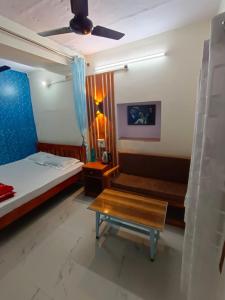 um quarto com uma cama, uma mesa e uma ventoinha de tecto em Sankardev Guest House D24 35 em Varanasi
