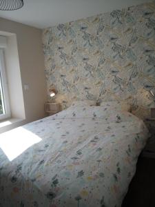 - une chambre avec un lit et un papier peint floral dans l'établissement R & C - Room & Calm, à Challans