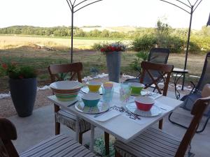 a table with bowls and plates on top of it at Charmante Dépendance en campagne in Samatan