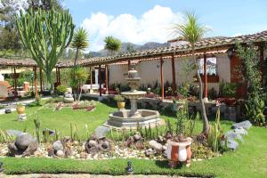 einen Garten vor einem Haus mit einem Brunnen in der Unterkunft HOTEL & SPA LAGUNA SECA in Los Baños del Inca