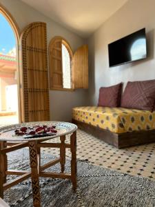 a living room with a bed and a table at Riad Fes Colors & Spa in Fès