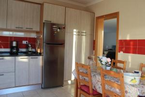 a kitchen with a stainless steel refrigerator and a table at VILLA ANDORINHA with Private Pool in a quiet area in Aljezur