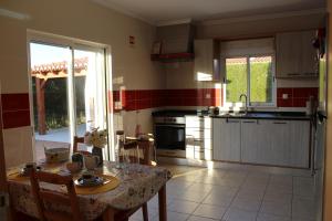 a kitchen with a table and a dining room at VILLA ANDORINHA with Private Pool in a quiet area in Aljezur