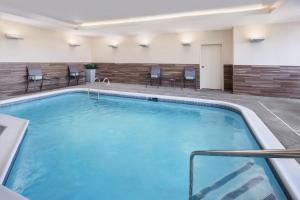 - une grande piscine dans une chambre d'hôtel avec des chaises dans l'établissement Fairfield Inn & Suites by Marriott Poplar Bluff, à Poplar Bluff