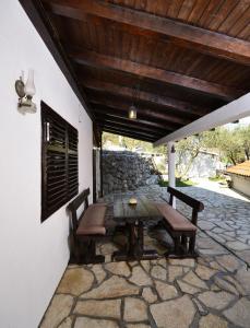 a patio with a table and chairs on a stone patio at Apartment Borovac in Vrgorac