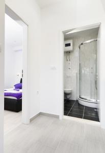 a white bathroom with a shower and a bed at Apartment Borovac in Vrgorac