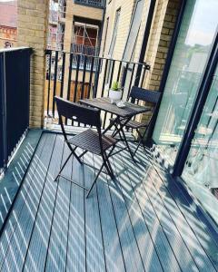 y balcón con mesa de patio y sillas. en Luxury 2 bed Serviced apartment in Dartford Kent, en Kent