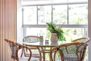 comedor con mesa, sillas y ventana en BravaSun: Prático Confortável Piscina 150m Praia, en Florianópolis