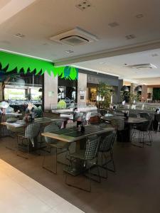 un restaurante con mesas, sillas e iluminación verde en Holandas Prime em Tambaú a 100mts da Praia, en João Pessoa