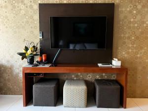 a television sitting on top of a table with two stools at Bonel condo at Pico de Loro in Cutad