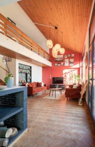 een woonkamer met rode muren en een houten plafond bij Villa avec vue panoramique in Charleville-Mézières