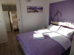 ein Schlafzimmer mit einem großen Bett mit einer lila Decke in der Unterkunft Bas de villa jardin plein sud proche mer clim-Wifi in Saint-Mandrier-sur-Mer