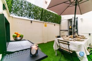 un patio con una mesa con un bol de fruta y una sombrilla en Premium Bajo Carlos Haya con Terraza y Parking, en Málaga