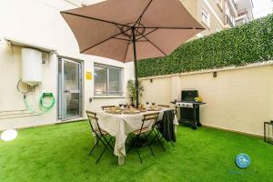 un patio con mesa y sombrilla en Premium Bajo Carlos Haya con Terraza y Parking, en Málaga