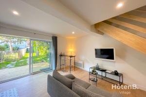 a living room with a couch and a tv at "La Boétie" - 50 m2 de charme Limoges Centre in Limoges