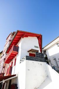 a white building with red and blue windows at PORTU ZARRA Bermeo in Bermeo