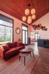sala de estar con sofá rojo y mesa en Villa avec vue panoramique, en Charleville-Mézières