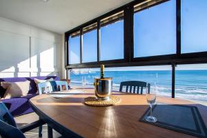 a dining room with a table with a bottle of wine at 13 ESPACIO SOBRE MAR in Cullera