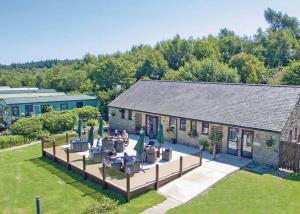 uma casa com um pátio com mesas e cadeiras em Springhouse Country Park em Slaley