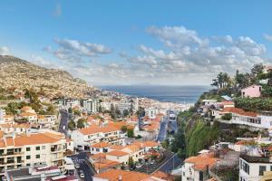 - une vue aérienne sur une ville avec des maisons et l'océan dans l'établissement Funchal House, à Funchal