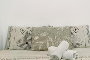 uma cama com duas almofadas e duas toalhas em Funchal House em Funchal
