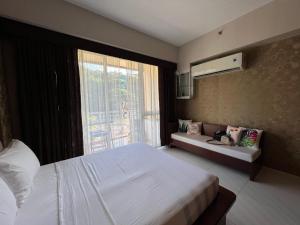 a bedroom with a large white bed and a window at Bonel condo at Pico de Loro in Cutad +14 photos