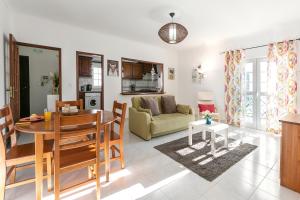 a living room with a table and a couch at Relax In Foz in Foz do Arelho