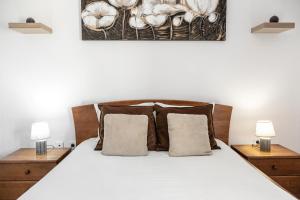 una camera con un letto bianco e 2 lampade di Relax In Foz a Foz do Arelho