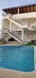 uma casa com piscina em frente a um edifício em Cabana Formosa T2 Férias Cabanas de Tavira em Cabanas de Tavira