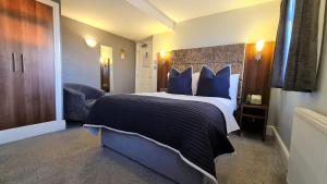 a bedroom with a large bed with blue pillows at Hotel Ocean in Great Yarmouth