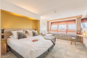 una camera con un grande letto e una finestra di La Cachette, Friendly Hotel & Spa ad Arc 1600