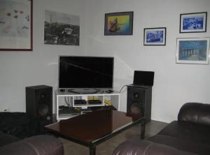 een woonkamer met een flatscreen-tv en luidsprekers bij QUARTO COM BANHEIRO PRIVATIVO in Sao Paulo