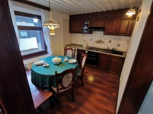a kitchen with a table with a green table cloth at Cosy Lake in Kranjska Gora