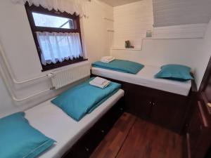 two beds in a small room with a window at Cosy Lake in Kranjska Gora