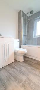 a bathroom with a toilet and a tub and a sink at Shanti in Darlington +23 photos