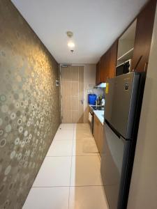 a small kitchen with a refrigerator and a tile floor at Bonel condo at Pico de Loro in Cutad