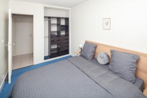 a bedroom with a large bed with blue sheets and pillows at Charmant 3 Pièces - RER à 100 M in Arcueil