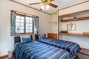 a bedroom with two beds and a ceiling fan at Beach House Yomitan in Yomitan