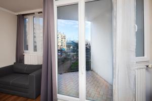 a room with a window with a view of a city at Charmant 3 Pièces - RER à 100 M in Arcueil