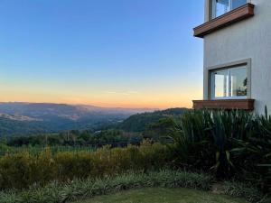 een huis op een heuvel met uitzicht op de bergen bij Apartamentos Residencial Toscano by Achei Gramado in Gramado