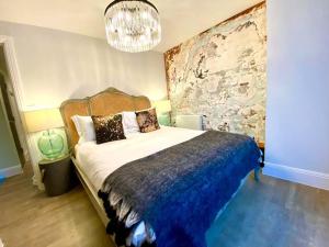 een slaapkamer met een groot bed en een kroonluchter bij Elegant Apartment - 1 Minute walk to Poole Quay - Great Location - Free Parking - Fast WiFi - Smart TV - Newly decorated - sleeps up to 2! Close to Poole & Bournemouth & Sandbanks in Poole