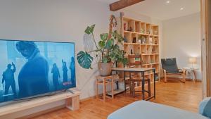 a living room with a large flat screen tv at L'Oustal des amis in Belcaire