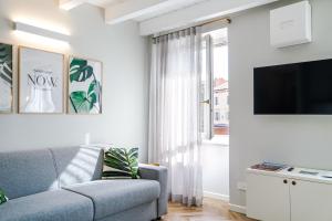 een woonkamer met een bank en een tv bij HomeThirtyFour in Verona