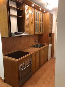 Una cocina con gabinetes de madera y un fregadero. en Bulevar NT Novi Beograd, Zemun, en Belgrado