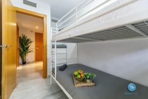 1 dormitorio con literas y un bol de fruta en Boutique Carlos Haya Malaga Apartment with parking, en Málaga