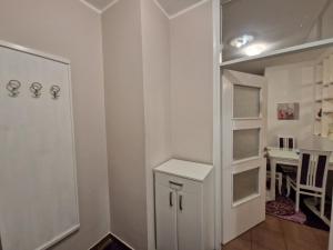 a white room with a white cabinet and a table at Your place in Podgorica in Podgorica