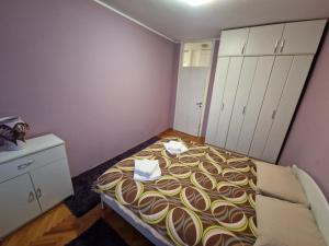 a small bedroom with a bed and white cabinets at Your place in Podgorica in Podgorica