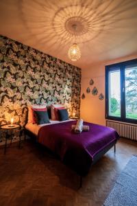 een slaapkamer met een groot bed met een paarse sprei bij Villa avec vue panoramique in Charleville-Mézières